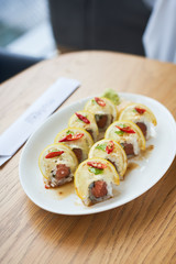    Japanes rice roll with salmon and lemon toped on the white plate