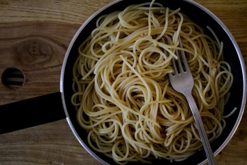 spaghetti in a pan on a background of spices, pasta
