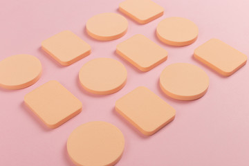 A lot of sponge, a beautiful blender for applying foundation or powder. Flat lay on a pink background, copy space.