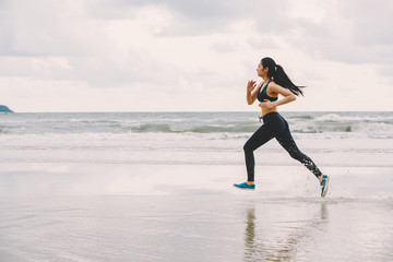 Runners. Young people running on beach. Athletic attractive people jogging on beach enjoying the sun exercising their healthy lifestyle.