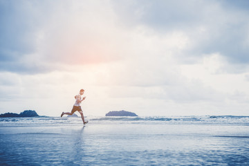 Runners. Young people running on beach. Athletic attractive people jogging on beach enjoying the sun exercising their healthy lifestyle.