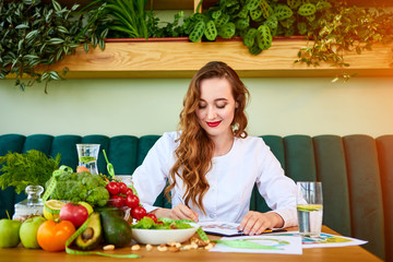 Woman dietitian in medical uniform with tape measure working on a diet plan sitting with different...