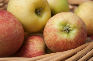 closeup of organic red apples in a wooden basket