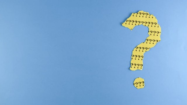 Stop motion - Footage of a moving question mark made from torn paper on a blue background with copy space. Concept of questions, quiz, riddle, faq, uncertainty and background. 4K mp4 high quality