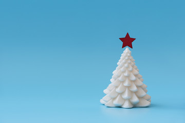 Christmas tree candle  on blue background. Christmas or New Year celebration concept. Copy space.