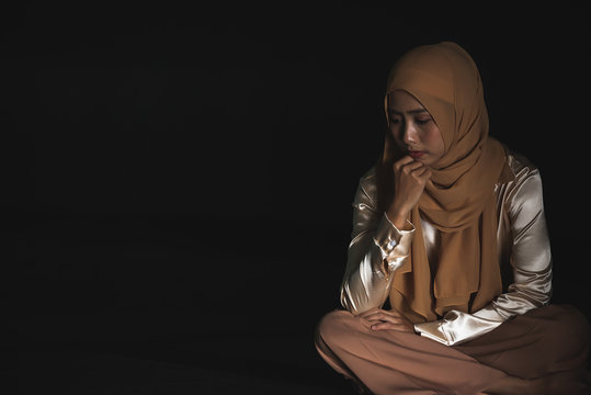 Young Muslim women sitting and feeling pain.. Lonely Muslim girl harly thinking how to solve life problem.