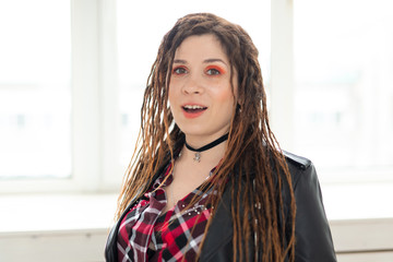 Dreadlocks, hairdresser and style concept - A stylish girl with dreadlocks and in leather jacket and fashionable makeup