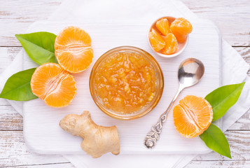 Orange jam in a jar, top view with fresh fruits