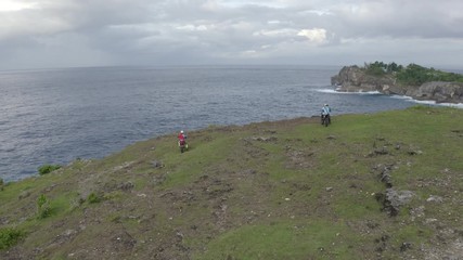 Motorbikers riding along cliff