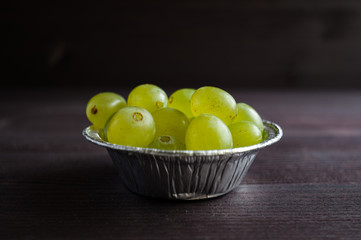 grape berries in a plate on a dark background