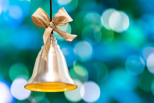 Christmas bell on the background of bokeh lights with copy space