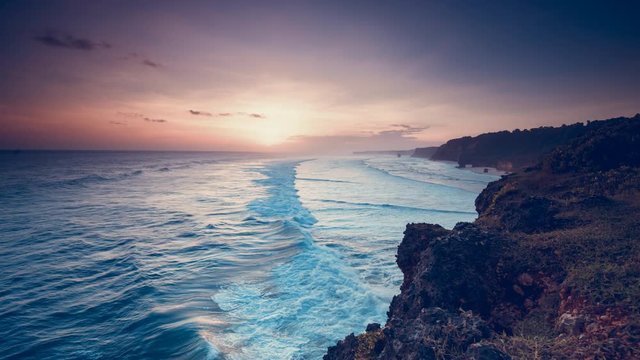 Wonderful Tanjung Benoa coastline beach against ocean surf and sunset in boundless orange sky time lapse. Concept travel recreation nature landscape of tropical island East Nusa Tenggara Indonesia. 4K