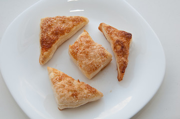 puffs of dough sprinkled with sugar on a white plate