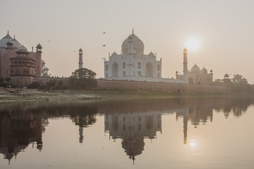 Fototapeta na wymiar Taj Mahal on sunset mirroring on the water - Agra India 