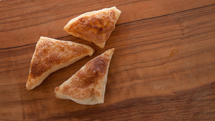 puffs of dough sprinkled with sugar on a wooden tray