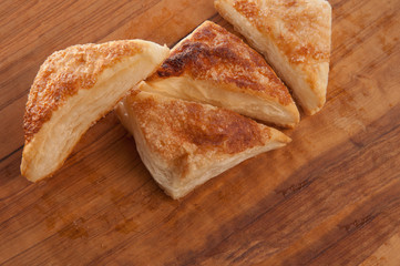 puffs of dough sprinkled with sugar on a wooden tray