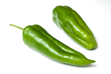 Closeup of organic green peppers on white background