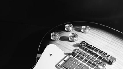 electric guitar . dark background . black and white .