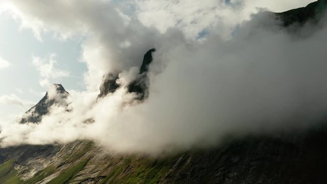 Mountains in the clouds near Trollstigen. Rauma Municipality in Norway.