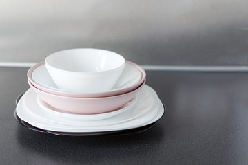Set of fresh washed plates and cutlery on the kitchen table.