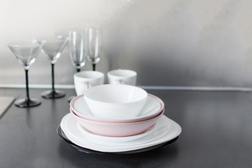 Set of fresh washed plates and cutlery on the kitchen table.