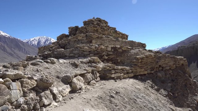 Pamir Highway Vrang Buddhist Stupa Low Angle Frontal View with Snow Capped Mountains at Background on a Sunny Blue Sky Day
