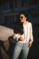 Woman walking with phone on the streets.