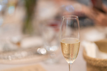 A Glass of champagne with blurred table party background.