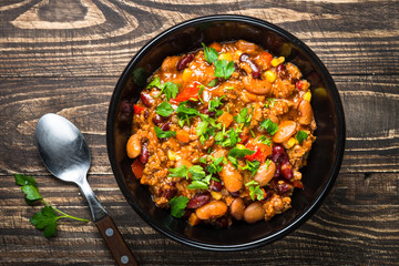 Chili con carne from meat and vegetables on wooden table top vie