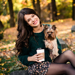 Beautiful woman walk with dog and drink coffee in the park.