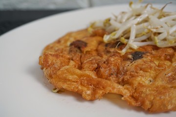 Thai street food Oyster omelet with fried  bean sprouts.