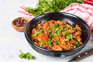 Chili con carne from meat and vegetables on stone table close up.