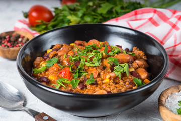 Chili con carne from meat and vegetables on stone table close up.