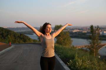 brunette woman does sports exercises outdoor