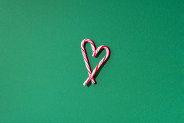 Christmas candy cane heart on green background with copy space. Top view. Love, Valentines day concept. New year and Christmas card