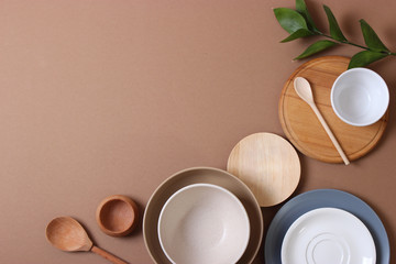 Set of dishes and kitchen utensils on a colored background top view.