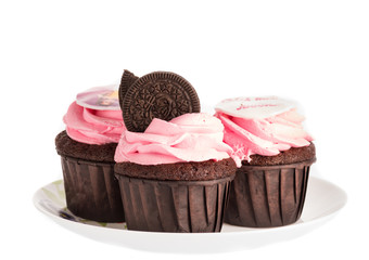 Cupcake cake with chocolate dough and pink cream on a white background