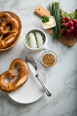 Münchener Weißwurst in Terrine mit bayrischer süßen Senf, Brezel, Radieschen, Schnittlauch und Butter auf Marmor Tisch