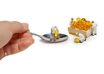 Little men serve fish oil in a teaspoon. Isolated on white background.