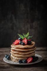 American pancakes with fresh berry on wood background. Summer homemade breakfast.