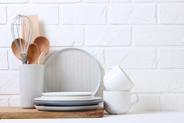A set of dishes and kitchen utensils on a colored background.
