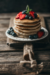 American pancakes with fresh berry on wood background. Summer homemade breakfast.