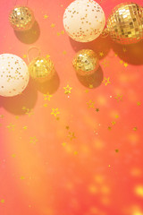 Christmas composition. Flat lay, top view. Disco ball bauble, star sparkles. Minimal New year party concept. Christmas white and gold decorations on red background with copy space.