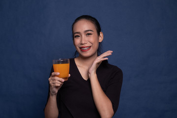 Happy Young Asian woman drink orange juice.