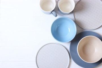 Set of dishes and kitchen utensils on a light background top view.