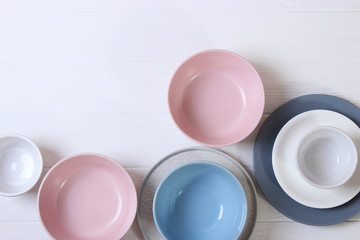 Set of dishes and kitchen utensils on a light background top view.