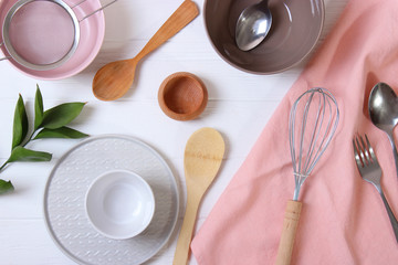 Set of dishes and kitchen utensils on a light background top view.