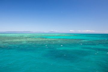 The Beautiful Great Barrier Reef from Above Aerial of Coral and Australia Mountains in Background with Blue Sky in Summer Weather