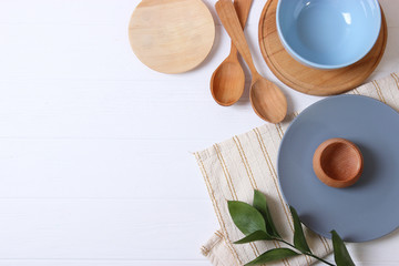Set of dishes and kitchen utensils on a light background top view.