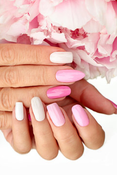 Light pink, pastel manicure on various shapes of nails with peony closeup.
